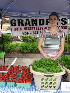 Person selling produce at a farmers market
