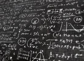 Mathematical equations on a chalkboard, representing scientific laws