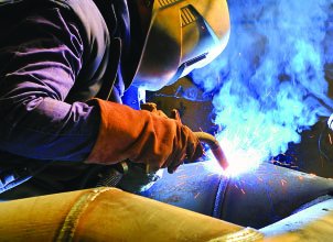 A welder using an oxyacetylene torch, which burns ethyne (acetylene) in oxygen