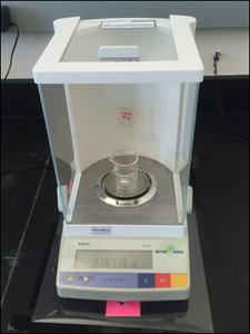 Electronic balance with a beaker displaying a mass reading