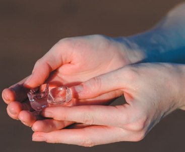 Hand holding ice, illustrating heat flow