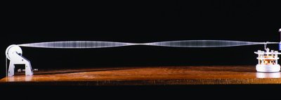Standing wave produced by a wave generator, showing nodes and antinodes along a wire.