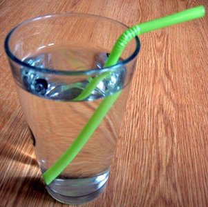A glass of water with dissolved sugar and a straw, illustrating a homogeneous solution