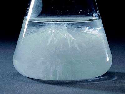 Crystallization occurring as temperature decreases, showing the formation of crystals in a supersaturated solution