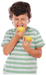 Child tasting a lemon, illustrating the sour taste of acids