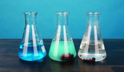 Three Erlenmeyer flasks showing different stages of a reaction involving zinc and copper(II) chloride solution