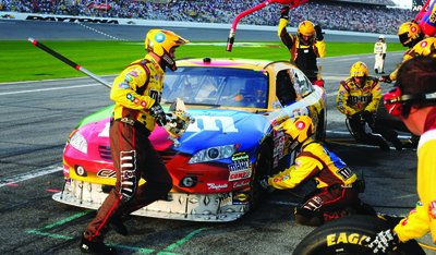 NASCAR pit crew refueling a car, illustrating the use of hydrocarbon fuels