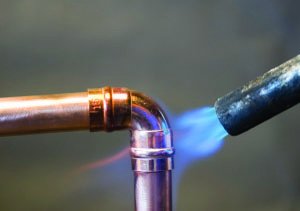 Propane torch being used to solder copper pipes