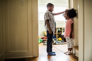 Children measuring height, illustrating phenotypic variance in a population