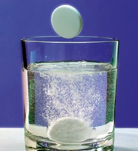 Antacid tablet undergoing a chemical reaction in water