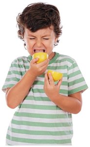 Child tasting a lemon, illustrating the sour taste of acids