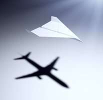 Paper airplane casting a shadow of a real airplane, illustrating model simplification