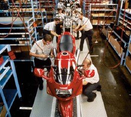 Workers assembling motorcycles in a factory, illustrating productivity and labor input