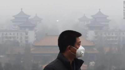 Person wearing mask in polluted city