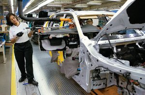 Automobile factory production line illustrating labor and capital resources