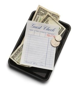 Money as a medium of exchange, illustrated by a restaurant bill and cash