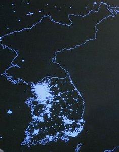 Satellite image of the Korean peninsula at night, showing stark contrast in economic development between North and South Korea
