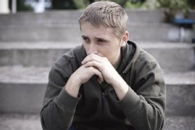 A person experiencing distress, representing the social costs of unemployment