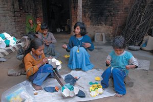 Children stitching soccer balls