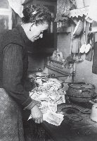 Woman using paper currency to light stove during German hyperinflation