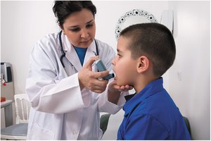 Healthcare provider administering metered-dose inhaler to child