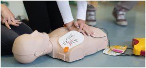 Woman practicing CPR on manikin