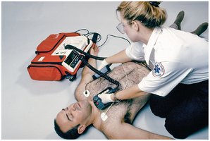 EMT using defibrillator paddles