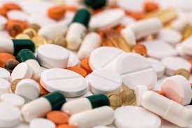 Assorted tablets and capsules representing antimicrobial agents