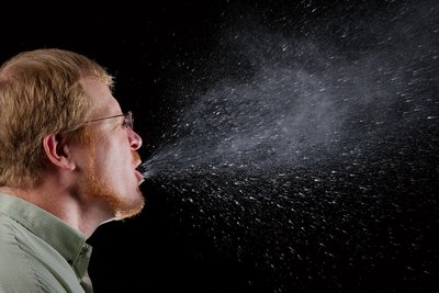 Person sneezing, showing droplet transmission