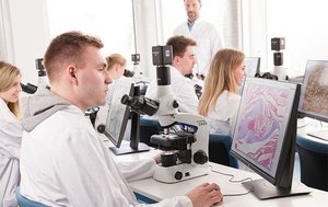 Students using brightfield microscopes in a lab