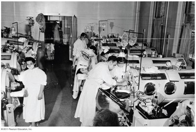 A hospital ward full of mechanical respirators (iron lungs) used for polio patients