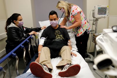 Emergency room nurse treating a patient with influenza (epidemic example)