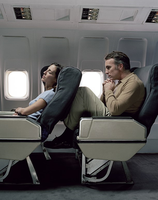 Passengers negotiating seat reclining on an airplane