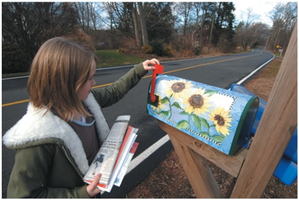 Person placing mail in a decorated mailbox