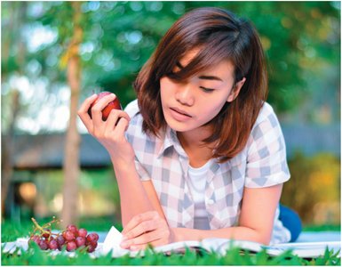 Person eating fruit, possibly influenced by advertising