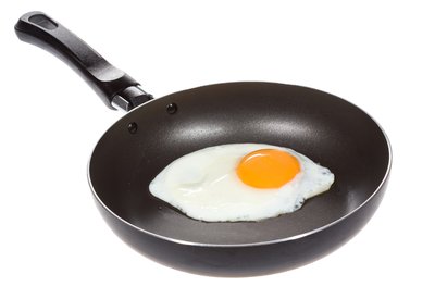 Egg being cooked in a frying pan as an example of protein denaturation by heat