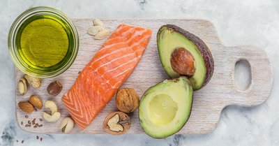 Salmon, avocado, nuts, and oil, representing plant and fish sources of healthy fats