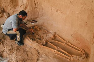 Archaeologist excavating a skeleton for radiological dating