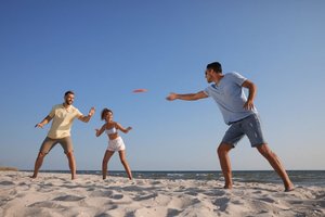 People playing frisbee on the beach
