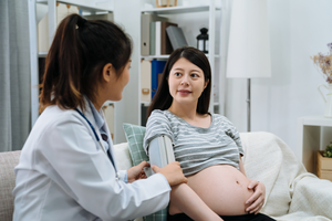 Doctor measuring blood pressure of pregnant woman