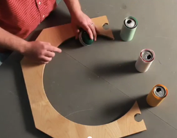 Ball rolling along circular track with cans
