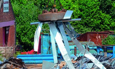 Electromagnet lifting scrap metal in a scrapyard