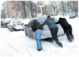 People pushing a car, illustrating work done by a force causing displacement