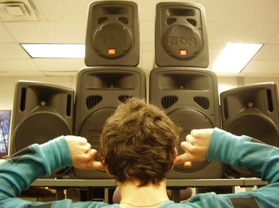 Person covering ears in front of loudspeakers