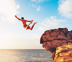 Person jumping off a cliff, representing free fall