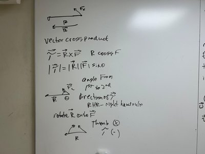 Whiteboard with vector cross product and torque diagrams