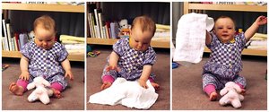 Baby playing with a blanket, demonstrating object permanence