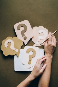 Decision making illustrated with question marks and a notebook