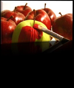 Green apple being painted red to match others, illustrating conformity and prejudice