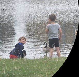 Two children exploring by a pond, illustrating independence and exploration in early childhood